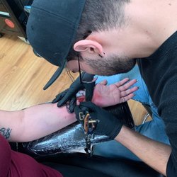 Waco Tattoo & Body Piercing - Tony tattooing my gf. Queen crown with red Queen playing card heart and the "Q"