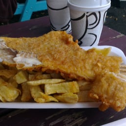 Haddock and chips, with a takeaway cup of mushy peas in thebackground. Haddock and chips, with a takeaway cup of mushy peas in thebackground.