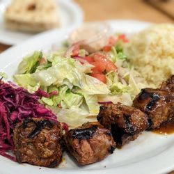 Mediterranean Kebab - Shlsh Kebab (Lamb-5 pieces) Plate with pickled cabbage, salad, mediterraneean rice. Pita bread (in background)