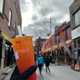 a person holding a cup of iced tea on a city street a person holding a cup of iced tea on a city street