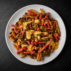 Fuego Cravings - Crispy seasoned fries loaded with rich nacho cheese, your choice of meat, spicy Hot Cheetos, and jalapeños for a fiery, flavor-packed bite.