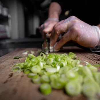 Dero Meal Prep - a person chopping green onions - Health Markets Near Me - Reno, Nevada