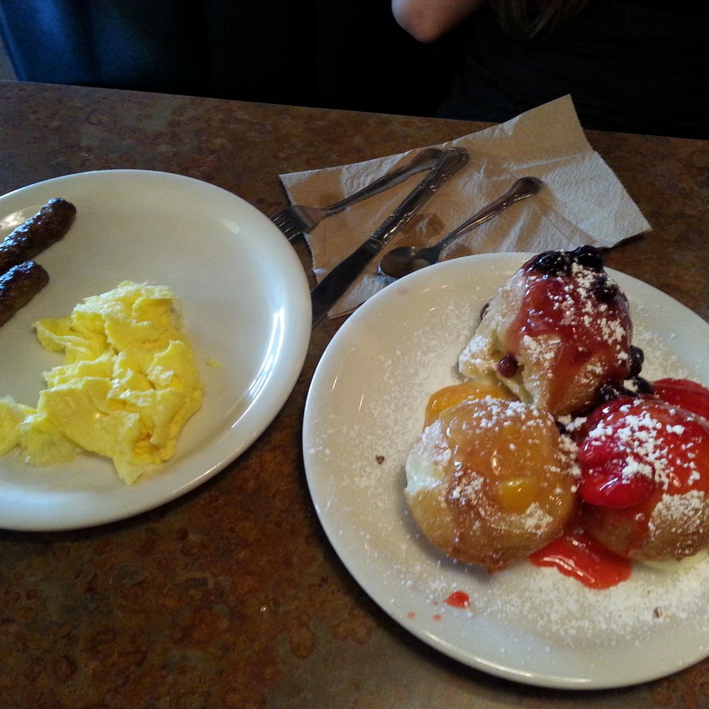 Huckleberry's - Beignet Meal- Three beignets topped with fruit and side of eggs and sausage/or bacon. - Breakfast & Brunch Near Me - Fairfield, California Huckleberry's - Beignet Meal- Three beignets topped with fruit and side of eggs and sausage/or bacon. - Breakfast & Brunch Near Me - Fairfield, California
