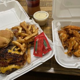 a burger and fries in a styrofoam container