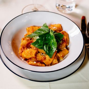 Felice 56 - A classic Italian dish of rigatoni pasta tossed in a rich red sauce and garnished with a cluster of fresh basil leaves, serve... - Italian Near Me - New York, New York Felice 56 - A classic Italian dish of rigatoni pasta tossed in a rich red sauce and garnished with a cluster of fresh basil leaves, serve... - Italian Near Me - New York, New York