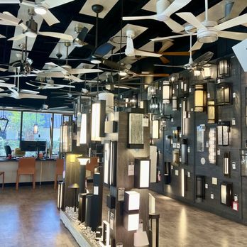 LBU Lighting - Ceiling fans are on display - Lighting store interior showcasing ceiling fans on the ceiling and a wall display of different lighting fixtures. - Lighting Stores Near Me - Boca Raton, Florida