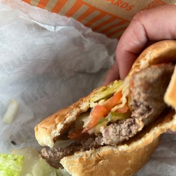 Whataburger - a hand holding a hamburger - Fast Food Near Me - Yulee, Florida