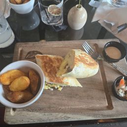Breakfast burrito with a side of home style potatoes Mexican style.