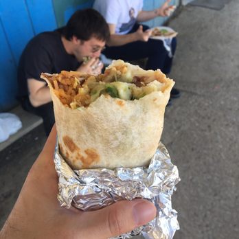 Three Rocks Market - a person eating a burrito - Mexican Near Me - Cantua Creek, California Three Rocks Market - a person eating a burrito - Mexican Near Me - Cantua Creek, California