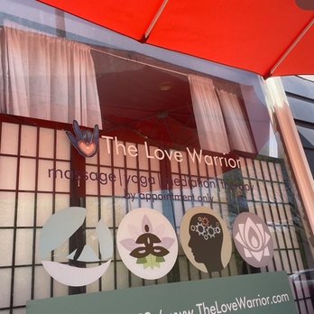 The Love Warrior - The Love Warrior massage and holistic therapy center's storefront features signage with icons representing massage, meditation, energy work, and holistic healing. - Yoga Near Me - Evanston, Illinois