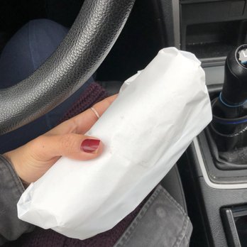 Bagel Buzz - a person holding a bagel in a car - Bagels Near Me - West Islip, New York Bagel Buzz - a person holding a bagel in a car - Bagels Near Me - West Islip, New York