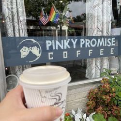 Pinky Promise Coffee Roasters - Coffee held in a hand outside the coffee shop