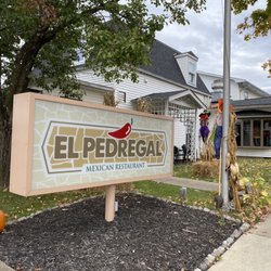 El Pedregal Mexican Restaurant - The street level sign with the restaurant in the background.