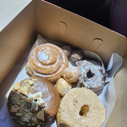 S'mores donut, cinnamon roll, chocolate cake donut with vanilla icing, strawberry cinnamon crumbs donut, and they threw in some donut holes.