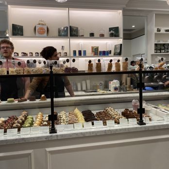 Maison Alyzee - Cakes on display; on the shelves behind the staff are jams, teas, coffees, and Advent calendars - Bakeries Near Me - Mountain View, California