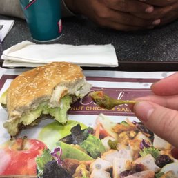 a person holding a cell phone and a plate of food