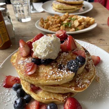 Milkweed - Fresh Berry Pancakes (front), home fries (middle), Chocolate Chip Pancakes (back) - New American Near Me - Boston, Massachusetts