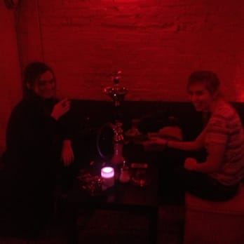 Crown Cafe - two people sitting at a table in a dimly lit room - Hookah Bars Near Me - Washington, DC, District of Columbia