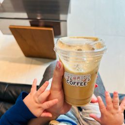 a baby holding a cup of coffee a baby holding a cup of coffee