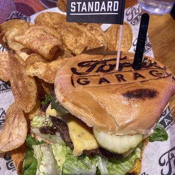 Ford's Garage Wesley Chapel - American standard burger with homemade chips. Great seasoning on the chips- big filling burger! Love the branded bun! - Burgers Near Me - Lutz, Florida