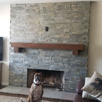 C Tan Construction - a living room with a stone fireplace - General Contractors Near Me
