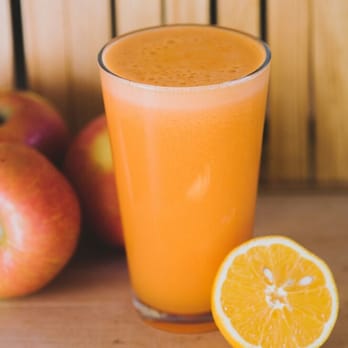The Valley Organic Deli - a glass of orange juice next to an orange slice - Delis Near Me - Everett, Washington