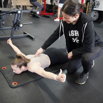 Austin Simply Fit - Our personal trainer  is coaching a client through a Prone T Raise. - Gyms Near Me - Austin, Texas