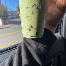 a hand holding a green smoothie