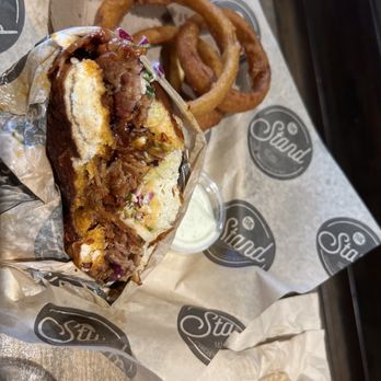 The Stand - American Classics Redefined - BBQ Brisket on a Pretzel Roll & onion rings - New American Near Me - Calabasas, California The Stand - American Classics Redefined - BBQ Brisket on a Pretzel Roll & onion rings - New American Near Me - Calabasas, California