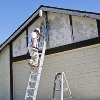 Schulze Exteriors - a man on a ladder painting a garage - General Contractors Near Me - Oshkosh, Wisconsin Schulze Exteriors - a man on a ladder painting a garage - General Contractors Near Me - Oshkosh, Wisconsin