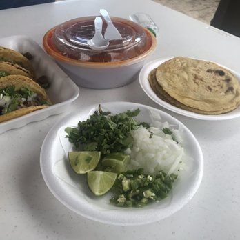 Taqueria La Unica - a table with tacos and salsa - Food Trucks Near Me - Okeechobee, Florida