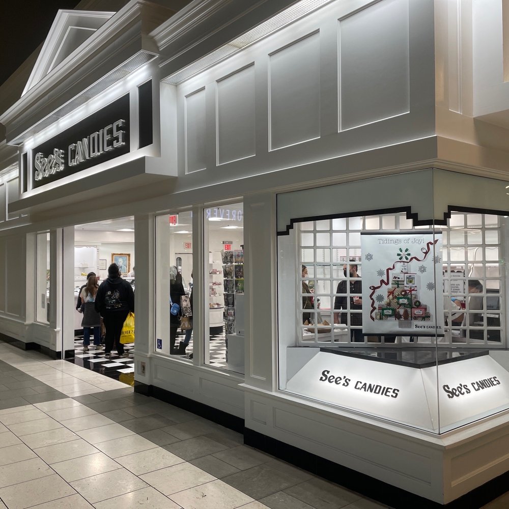a storefront with people walking by a storefront with people walking by
