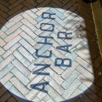 Anchor Bar - The word 'DANGER' is projected onto a brick sidewalk using a light source, creating a shadow effect. - Bars Near Me - Baltimore, Maryland