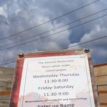 The Kosmos - A weathered sign shows The Kosmos Restaurant hours during construction, with weekday and weekend timings and reservation advice. - Bars Near Me - Albuquerque, New Mexico