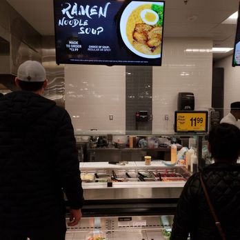 Carrs - a man and a woman standing in front of a food counter - Grocery Near Me - Anchorage, Alaska Carrs - a man and a woman standing in front of a food counter - Grocery Near Me - Anchorage, Alaska
