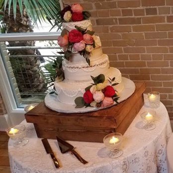 Plantiques - Wedding cake with wrap around bunches of flowers, and floating candles at the base - Florists Near Me - Bulverde, Texas
