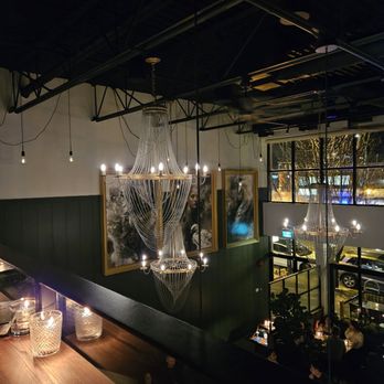 The Watson - a dining area with a long table and a chandelier - Cocktail Bars Near Me - Vancouver, British Columbia