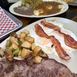 Steak & Eggs | Tree eggs cooked your way, two bacon strips, breakfast potatoes and steak. Served with warm tortillas or toast.