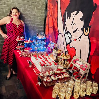 The Nest Bar & Eatery - a woman standing in front of a table full of desserts - Sports Bars Near Me - Chicago, Illinois The Nest Bar & Eatery - a woman standing in front of a table full of desserts - Sports Bars Near Me - Chicago, Illinois