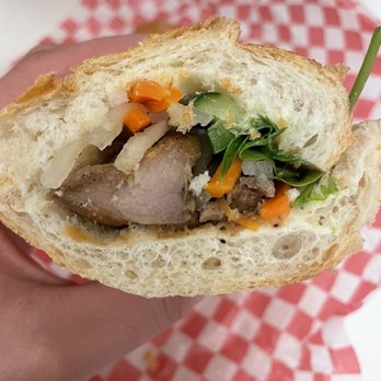 Saigon Bites - a hand holding a half eaten sandwich - Sandwiches Near Me - Burnaby, British Columbia