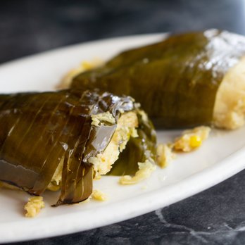 La Cabaña - a white plate with two stuffed grape leaves - Honduran Near Me - Seattle, Washington La Cabaña - a white plate with two stuffed grape leaves - Honduran Near Me - Seattle, Washington