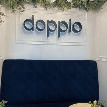 Doppio Cafe & Creperie - Doppio logo and tables in front of banquette seating. - Coffee & Tea Near Me - Redmond, Washington