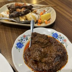 Sambal - Rendang (roasted beef cubes is a rich, spicy sauce) and beef kabobs over rice cakes.