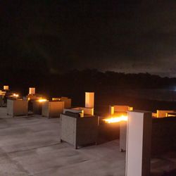 The Cape Club of Palm City - Patio view at night with the fire pits lit.