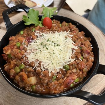 Clerico - a skillet of food on a wooden table - Argentine Near Me - Killeen, Texas Clerico - a skillet of food on a wooden table - Argentine Near Me - Killeen, Texas