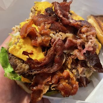 Burger Time - Double Texas pastrami cheeseburger - A burger with bacon, scrambled eggs, shredded meat, and lettuce, served in a paper wrapper. - Burgers Near Me - Merced, California