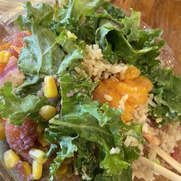 a salad in a plastic bowl with chopsticks