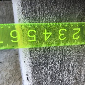 Spring Dance Hot Tubs - A bright green measuring tape is laid across a textured concrete wall, showing measurements in inches. - Hot Tub & Pool Near Me - Jamison, Pennsylvania