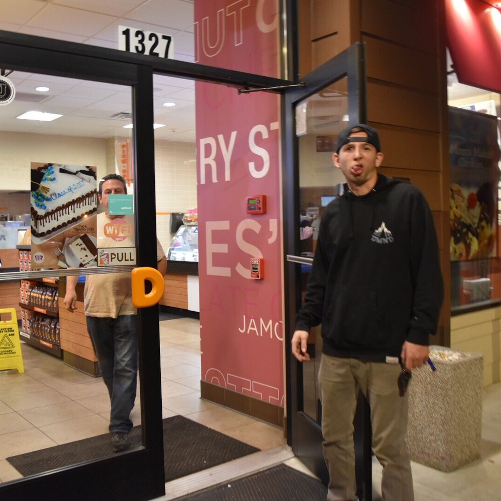 Dunkin' -  a man standing in front of a door - Donuts Near Me - Centereach, New York