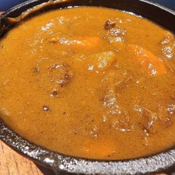 The Chubby Curry, in small cast iron pot served with a side bowl of rice and broccoli